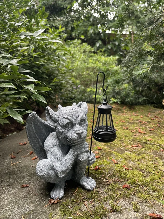 A small stone gargoyle statue standing guard in a customer's garden